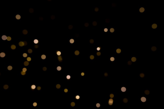 Photo black background with bokeh golden light effects for christmas time photo