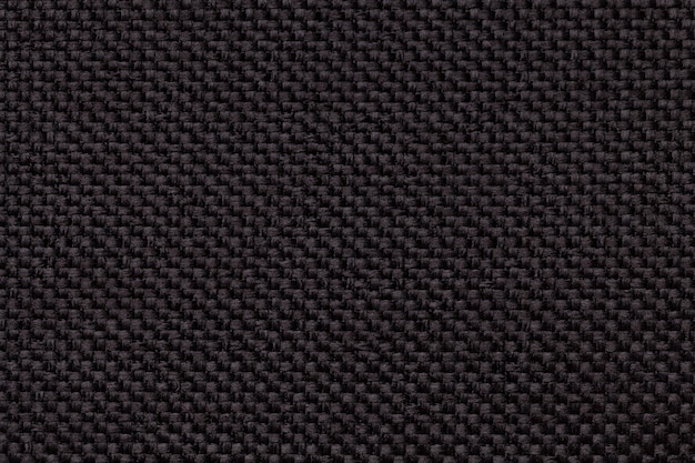 Black background with braided checkered pattern, closeup. Texture of the weaving fabric, macro