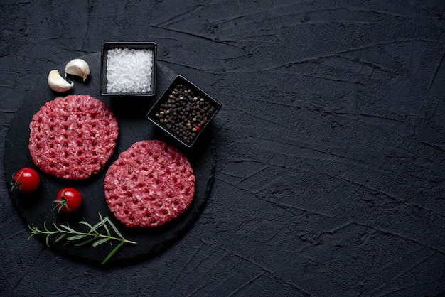 A black background with a set of hamburger patties.