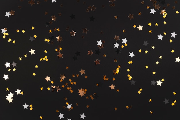 Black background with stars that shine and shimmer in yellow Happy new year background copy space