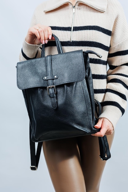 Black backpack on the shoulder of a woman Women's backpack gray women's backpack Women's bag isolated on white background The bag is isolated on a white background