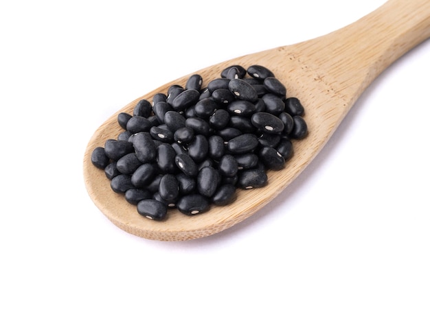 Black beans on a spoon isolated over white background