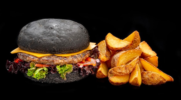 Black beef burger with french fries isolated on black background