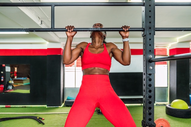 Black bodybuilder athlete in a sports gym doing a barbell back exercise . Concept of strengthening the body in gym