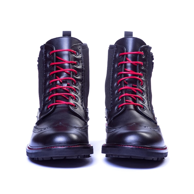 Black boot with red laces on a neutral white background