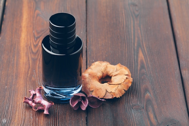 Black bottle of perfume placed on a wooden table