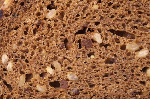 Black bread with sunflower seeds background texture. Macro photo