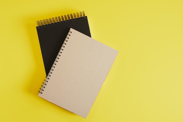 Black and brown kraft notepad for sketching or writing spiral on yellow background mockup drawing pads