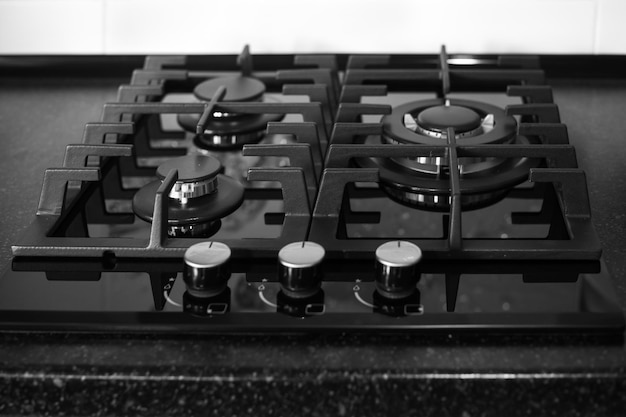 Black builtin gas stove on a black countertop Kitchen interier