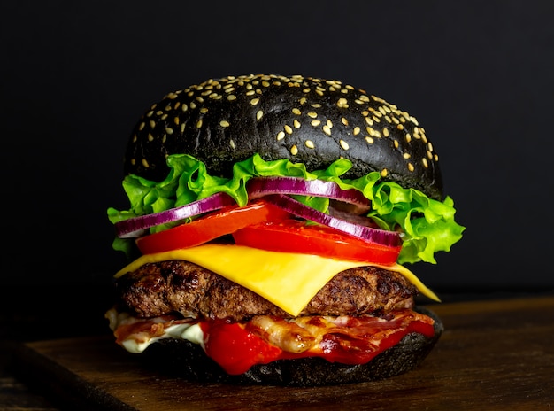 Black burger on a black. Cheeseburger. Recipes. Fast food.