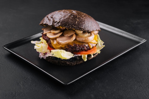 Black burger with beef and mushrooms