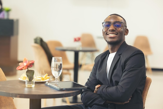 A black businessman works on his laptop in a cafe