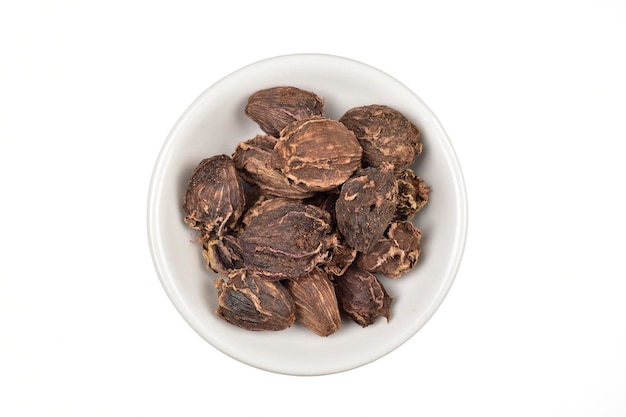 Black cardamom in bowl isolated on white background with clipping path