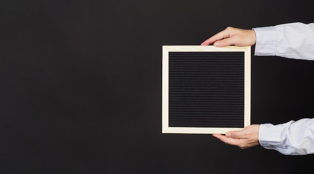 Black changeable letter board In hands with horizontal frame