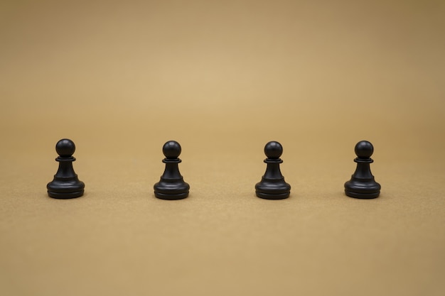 Black chess pieces on brown surface