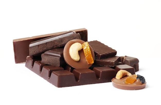 Black chocolate bar and candies isolated on a white background.