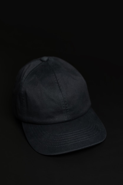 Black cloth cap / hat on the dark black background.