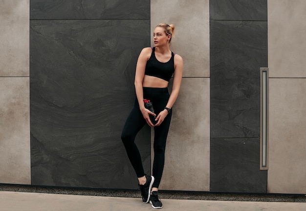 Black clothing for sports, Woman in sports tops, Girl at the wall, Girl with a shaker