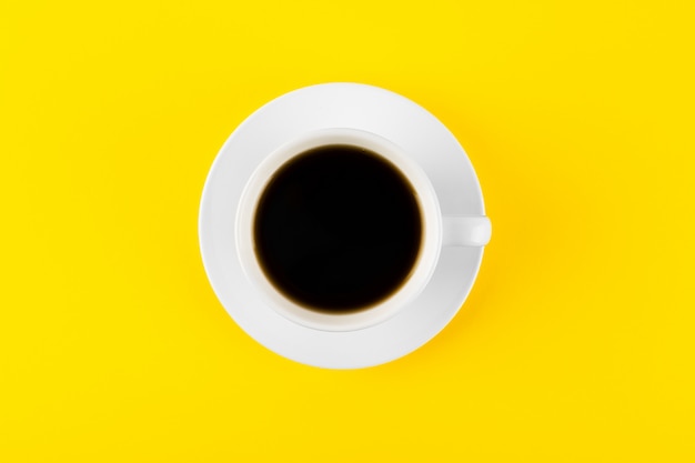 Black coffee in a cup on a yellowtable