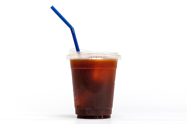 Black coffee or ice americano in a cup with blue straw on white background ready to serve