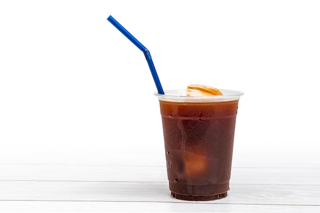 Black coffee or ice americano in a cup with blue straw on white background ready to serve