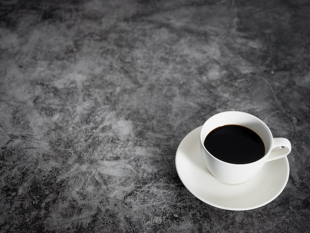 Black coffee white cup on dark floor table copy space