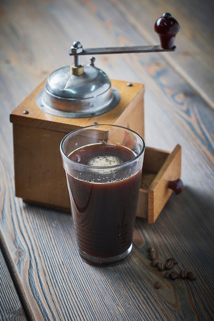 Black coffee with coffee grinder placed