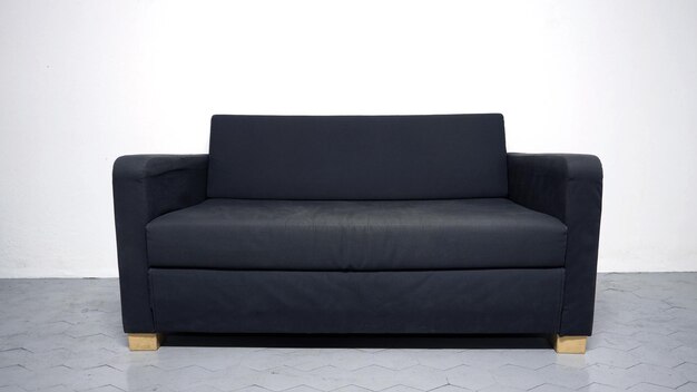 Black color sofa that made from wood and fabric in the white room and grey floor and no people