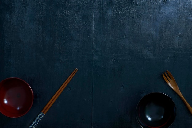 Black color wooden table top view On the table are the Japanese wooden spoon chopsticks bowl