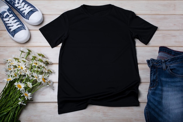 Black cotton Tshirt mockup with wild daisy flowers bouquet and jeans Design t shirt template tee print presentation mock up