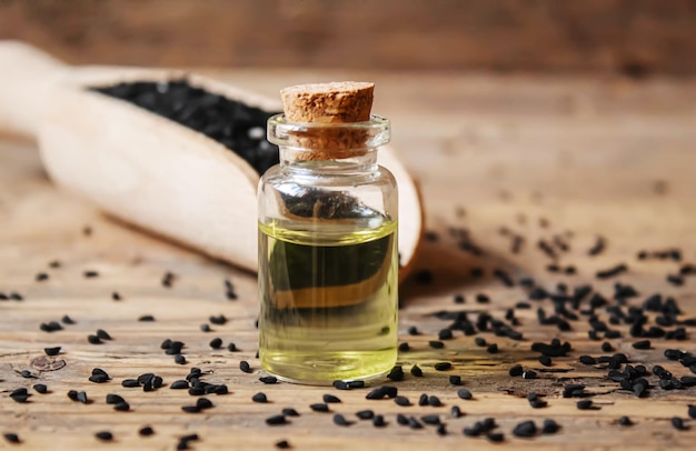 Black cumin essential oil in a small bottle Selective focus