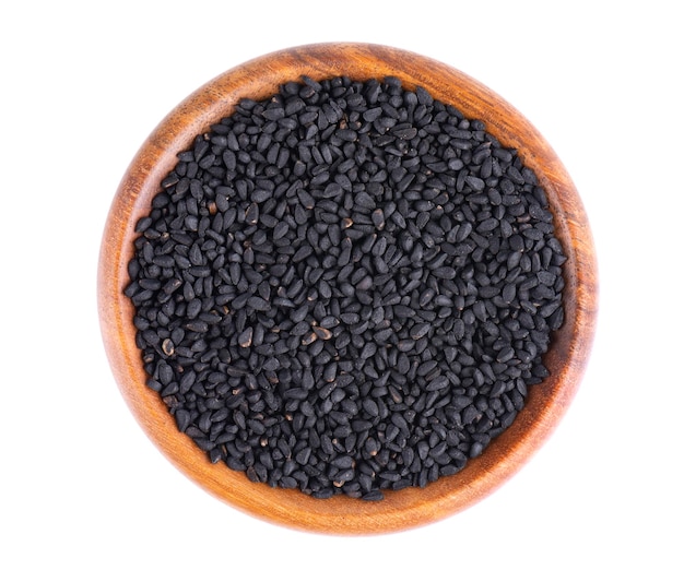 Black cumin seeds in wooden bowl isolated on white background Heap of black nigella seeds Nigella sativa Top view