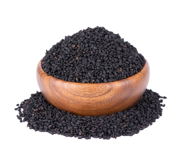 Black cumin seeds in wooden bowl isolated on white background Heap of black nigella seeds Nigella sativa