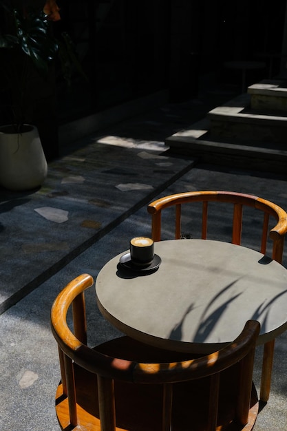 Black cup of coffee with milk foam on top view on cement table