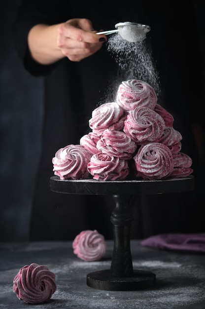 Black currant marshmallows Zefir Confectioner sprinkles marshmallows with powdered sugar