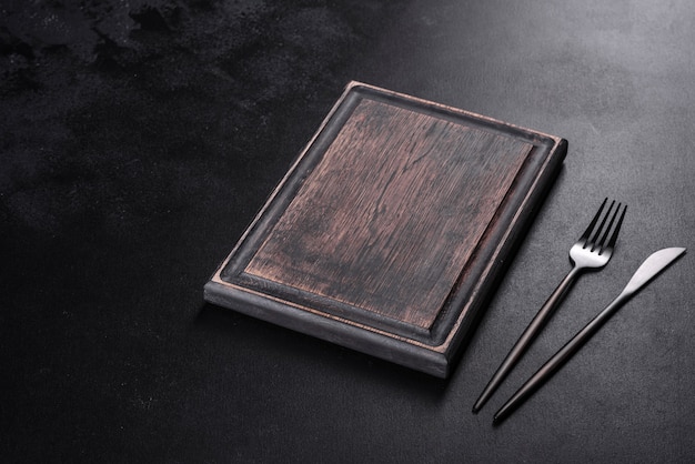 Black cutlery on a concrete dark table. Dining table preparation