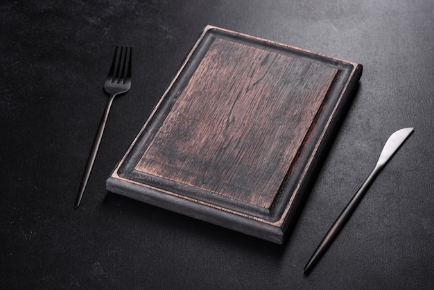 Black cutlery on a concrete dark table. Dining table preparation