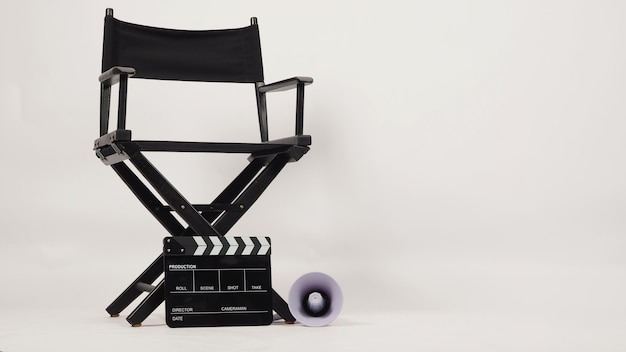 Black director chair and black clapper board with yellow megaphone on white background