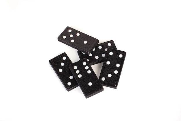 Black domino pieces on a white background with copy space in a top up view