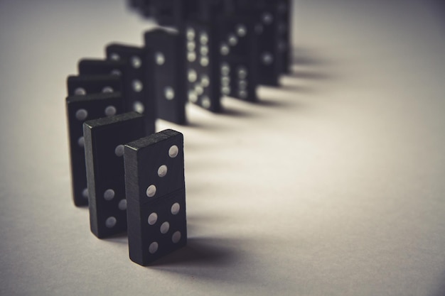 Black dominoes chain on table background