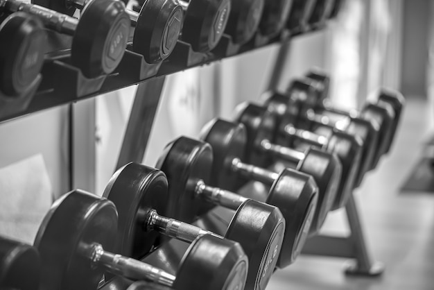 Black dumbbell set Close up many metal dumbbells on rack in sport fitness center  Weight Training