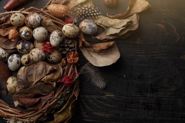 Black eggs in a nest of dry branches on a black board. Easter style.