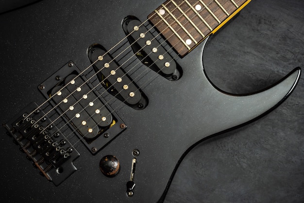 Black electric guitar on black cement floor. Top view and copy space. Concept of rock music.