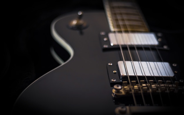 Black electric guitar on dark