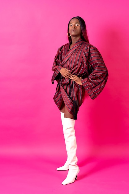 Black ethnic man in a studio LGTBI concept portrait wearing a red kimono and white high heels