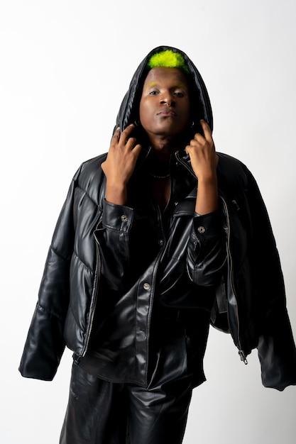 Black ethnic man in studio with white background LGTBI concept posed with leather jacket hat