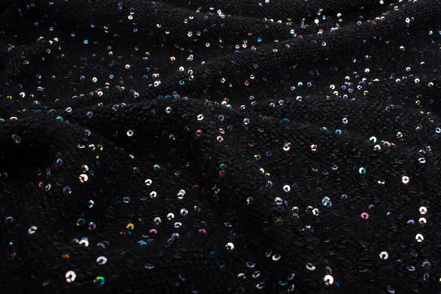 Black fabric with sequins. Cloth paillettes Background texture, pattern