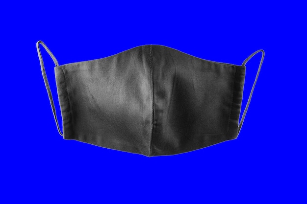 Black face protective mask on a blue background. Reusable face mask isolated. Face antivirus mask