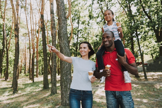 Black Father Carries Daughter On Neck In Forest.