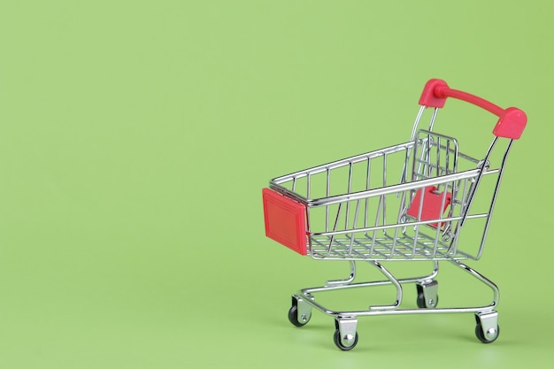 Black Friday. Purchases. shopping Red shopping trolley on a green background